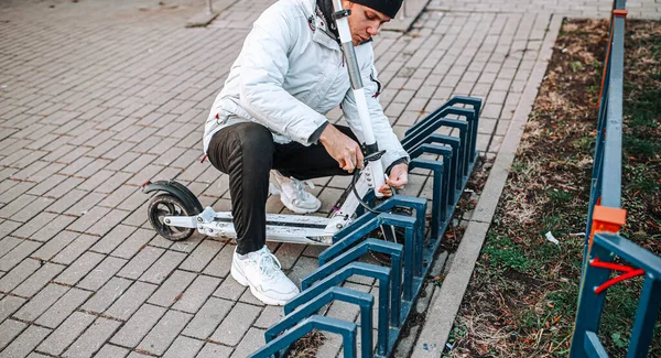 Homem Trava Uma Fechadura Cabo Uma Scooter Elétrica Estacionamento Bicicletas — Fotografia de Stock