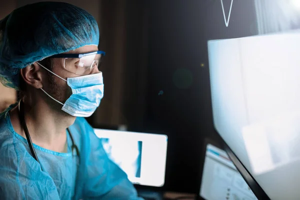 Muž Ochranné Uniformě Brýle Epidemiologa Lékař Dívá Obrazovku Nemocnici Noci — Stock fotografie