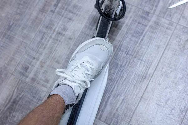 Ανδρικό Πόδι Sneaker Στέκεται Στο Νέο Σύγχρονο Ηλεκτρικό Σκούτερ Φόρτιση — Φωτογραφία Αρχείου
