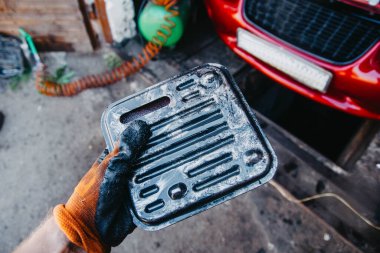 Otomatik aktarım onarımı sırasında erkek el yeni yağ filtresi tutuyor