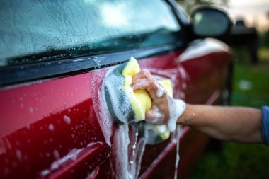 Kırmızı bir arabayı ellerinle yıka, kancayı da arabanın arkasında köpükle..