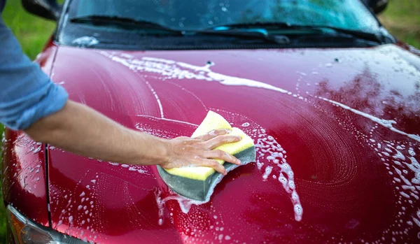 赤い車を手で洗い車の後ろに泡のついたフック — ストック写真