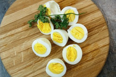 Mutfaktaki ahşap bir tahtanın üzerinde haşlanmış yumurta kes.