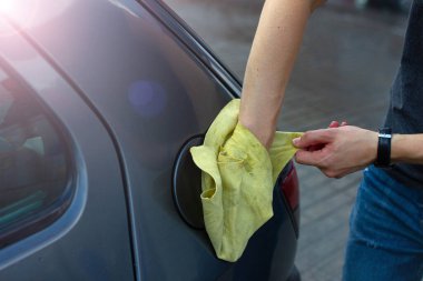 El yıkamada mavi arabayı temizleyen erkek elleri yakın plan.