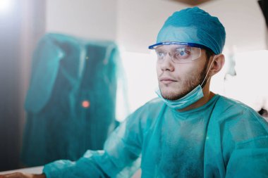 Estetik cerrah, ameliyattan sonra bilgisayarda tıbbi verileri inceler.