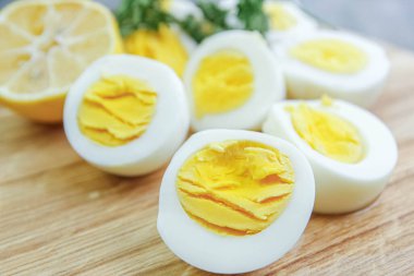 Mutfaktaki ahşap bir tahtanın üzerinde haşlanmış yumurta kes.