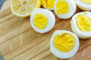 Mutfaktaki ahşap bir tahtanın üzerinde haşlanmış yumurta kes.