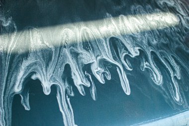 Mavi arabanın manuel oto yıkamada yakın çekimi.