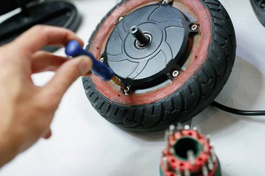 Motorlu taşıt tamirinde scooter tekerleği tutan adam. Çevre dostu elektrikli araç tamir hizmeti