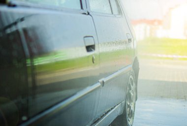 Mavi arabanın manuel oto yıkamada yakın çekimi.