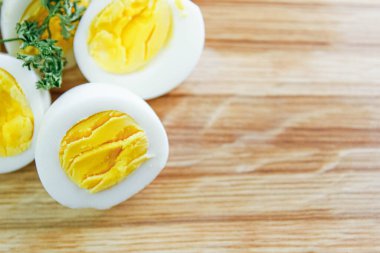 Mutfaktaki ahşap bir tahtanın üzerinde haşlanmış yumurta kes.