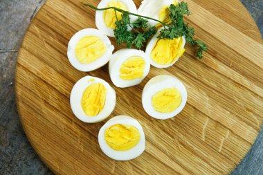 Mutfaktaki ahşap bir tahtanın üzerinde haşlanmış yumurta kes.