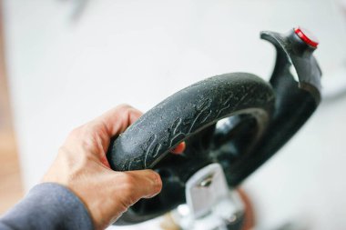 Motorlu taşıt tamirinde scooter tekerleği tutan adam. Çevre dostu elektrikli araç tamir hizmeti