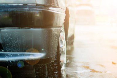 Mavi arabanın manuel oto yıkamada yakın çekimi.