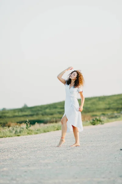 Кудрявая Молодая Женщина Танцует Романтически Голубом Платье Песчаной Дороге Закате — стоковое фото