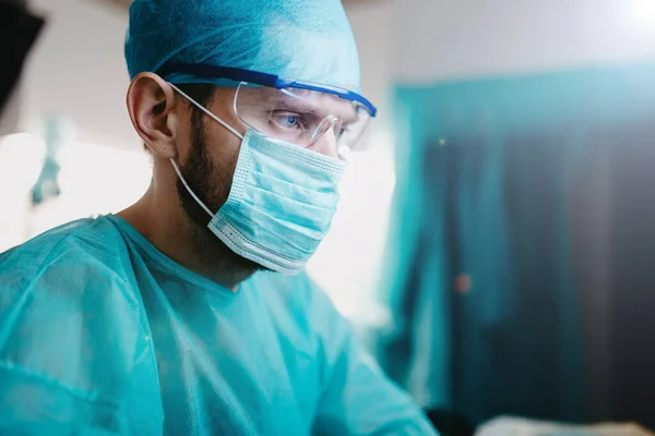 Άντρας Χειρουργός Γιατρός Σκέφτεται Πάνω Από Μια Εργασία Στο Εσωτερικό — Φωτογραφία Αρχείου