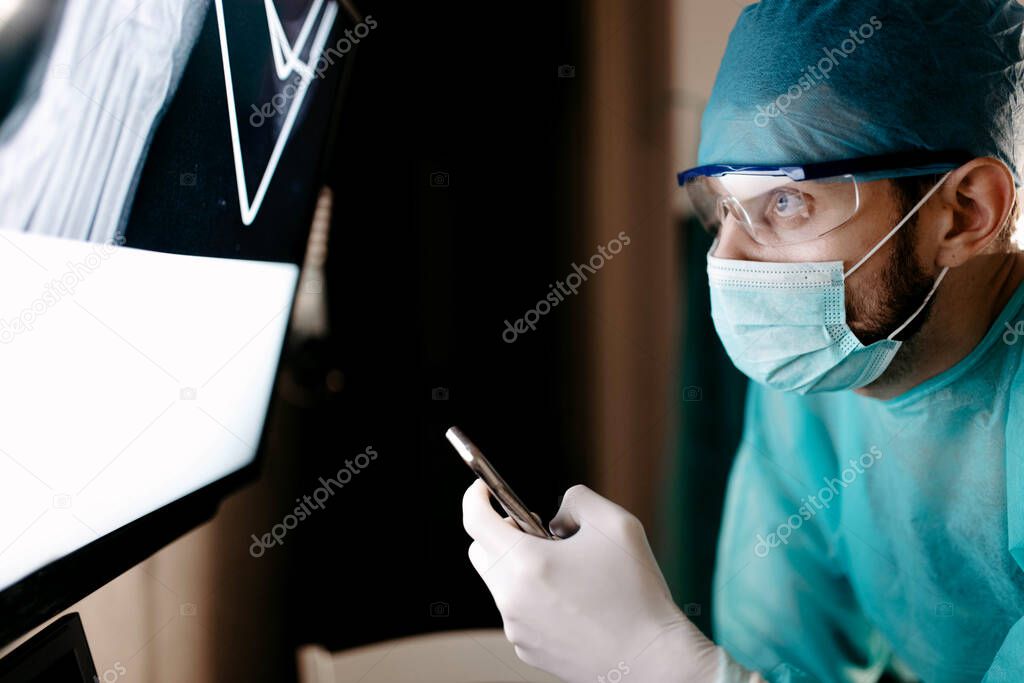 male surgeon orthopedic traumatologist touches a touch screen with a x-ray of the bone