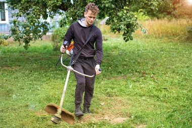  İnsan köyün bahçesindeki çimleri biçer..