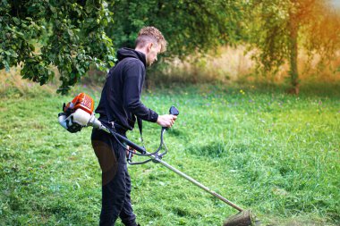  İnsan köyün bahçesindeki çimleri biçer..