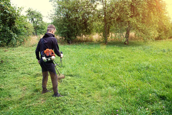 Uomo Taglia Erba Nel Giardino Del Villaggio — Foto Stock