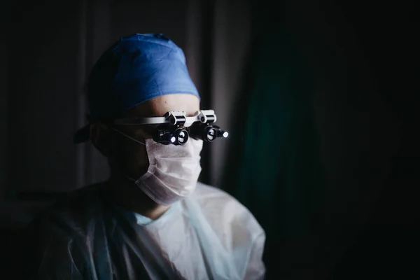 Surgeon Wearing Binocular Magnifying Glasses Operates Patient Dark Operating Room — Stock Photo, Image