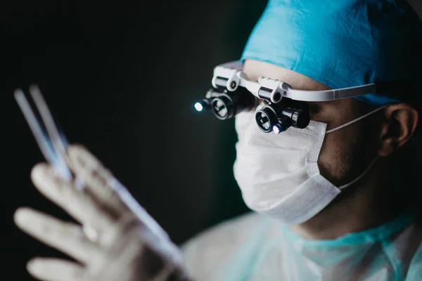 Хірург Бінокулярних Збільшувальних Окулярах Працює Пацієнта Темній Операційній Кімнаті — стокове фото
