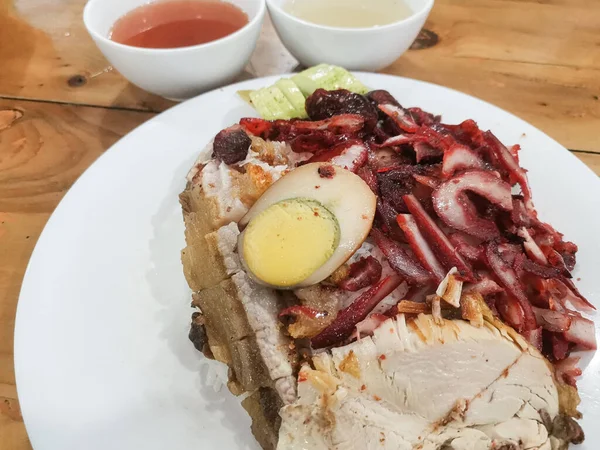 Lezzetli bir tabak char siu pilavı, leziz dilimlenmiş domuz eti ve yarım yumurtayla servis edilen, iştah açıcı bir Asya yemeği ve aşçılık lezzeti sunan, kaselerde çorba ile birlikte.