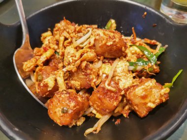 Lezzetli bir porsiyon kızarmış havuçlu kek yanında taze fasulye filizi ve çırpılmış yumurta, zarif bir siyah tabakta servis edilir. Bu lezzetli Asya yemeğinin tadını çıkar..