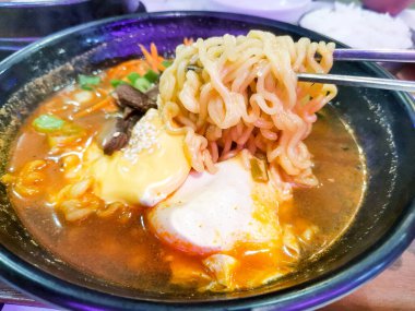 Bir kase baharatlı ramen çorbası, ramen çorbası ve kaynatılmış yumurta ve taze sığır eti, unutulmaz bir Asya mutfağı deneyimi için mükemmel. Lezzetli, ağız sulandırıcı sunumunun ve lezzetli aromasının tadını çıkar..