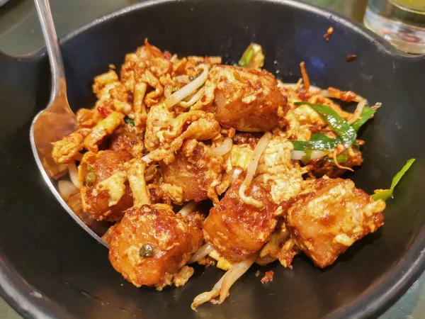 Lezzetli bir porsiyon kızarmış havuçlu kek yanında taze fasulye filizi ve çırpılmış yumurta, zarif bir siyah tabakta servis edilir. Bu lezzetli Asya yemeğinin tadını çıkar..