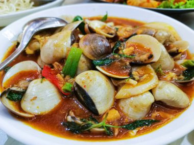 Aromatik bir çorba ve renkli sebzelerin içindeki bu cazip beyaz istiridye tabağının tadını çıkarın. Bir Tayland restoranı tarafından sunulan ve unutulmaz bir yemek deneyimi vaat eden bir aşçılık buluşu..