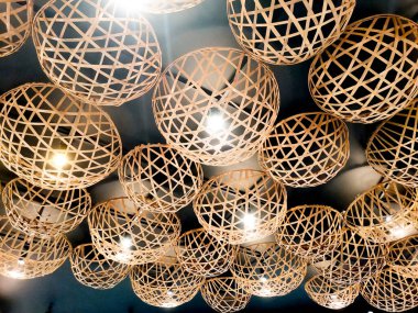 Dokuma küre ışıklarının büyüleyici bir düzeni büyüleyici bir görsel şablon yaratıyor. Mekanı sıcak ve davetkar bir ışıltıyla aydınlatıyor. Benzersiz bir sanat ve modern iç tasarım sergiliyor..