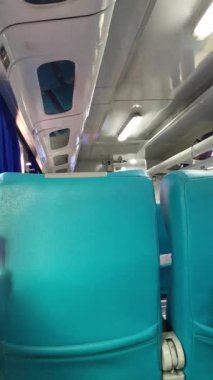 Hareket halindeki bir trenin içinden, sabah güneşiyle aydınlatılan koltukları, pencereleri ve iç manzaraları aydınlatan rahatlatıcı bir görsel perspektifin keyfini çıkarın. Seyahat, seyahat veya ulaşım temaları için ideal