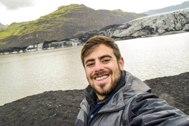 İzlanda'daki Solheimajokull buzul önünde selfie alarak adam