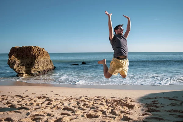 Happy man jumping on the beach