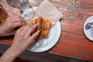 Yeni pişmiş bir kruvasanın bir parçasını koparmak.