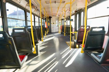 Boş koltukları ve sarı koltukları olan bir kamu otobüsünün içi..