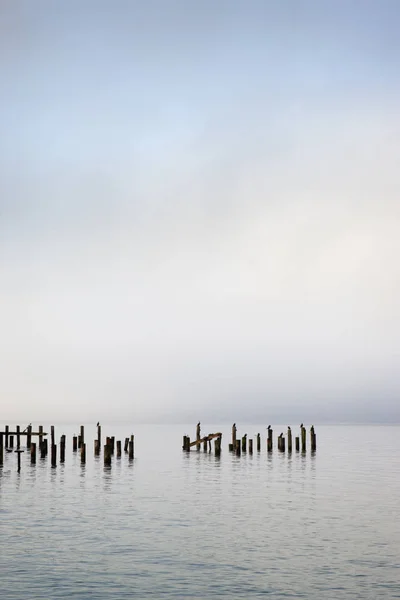 Holzstangen Ozean Unter Wolkenverhangenem Himmel — Stockfoto