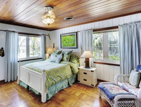 Спальня з дерев'яною стелею і затишним ліжком — стокове фото