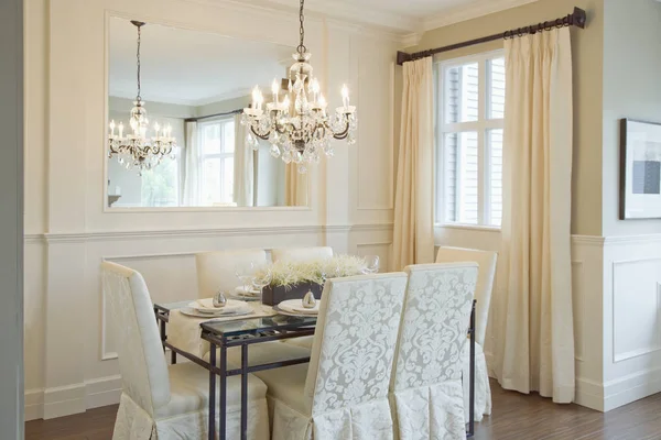 Salle à manger de luxe avec chaises, table et lustre suspendu — Photo de stock