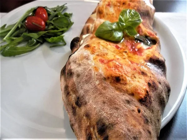Neapolitan pizza, stuffed, cooked in a wood oven.