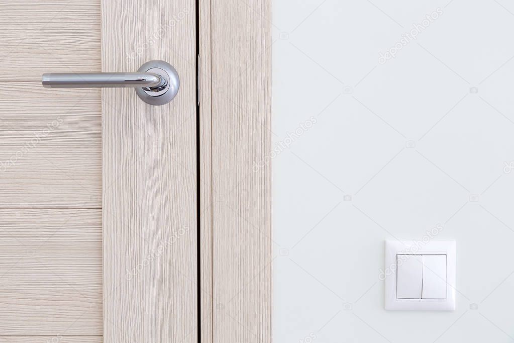 Interior detail. A door handle and a light switch