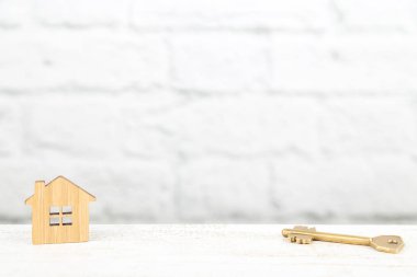 Dekoratif ahşap bir ev ile bir anahtar sembolü. Özel mülkiyet kavramı