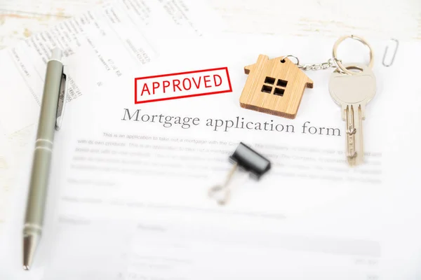 Approved mortgage loan agreement application with a house shaped keyring