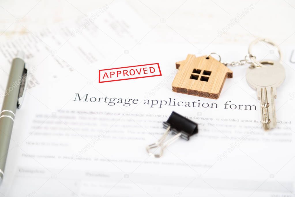 Approved mortgage loan agreement application with a house shaped keyring