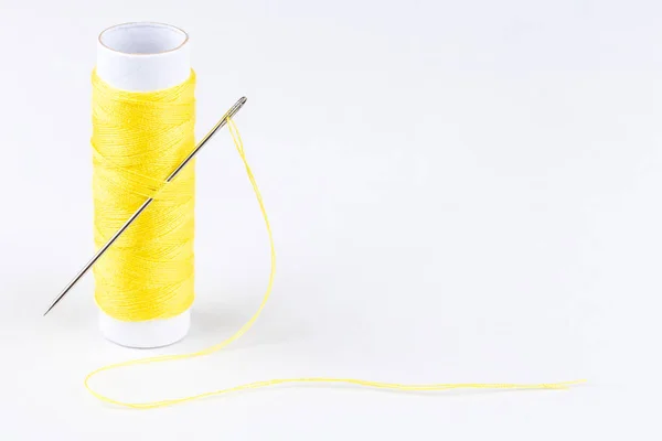 黄色のスレッドと白地に針のスプール — ストック写真