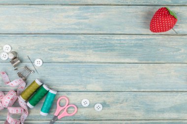 Araçlar dikiş ve iğne işi yeşil ahşap zemin üzerinde. Düz kopya alanı ile yatıyordu