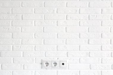 Güç ve tv priz ve beyaz tuğla duvar üzerinde baş alanı satırı