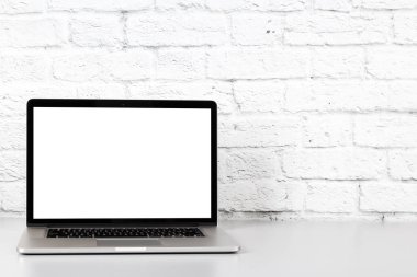 Ofis Masaları boş ekrana sahip dizüstü bilgisayarı. Mockup ile kopya alanı üzerinde tuğla duvar arka plan