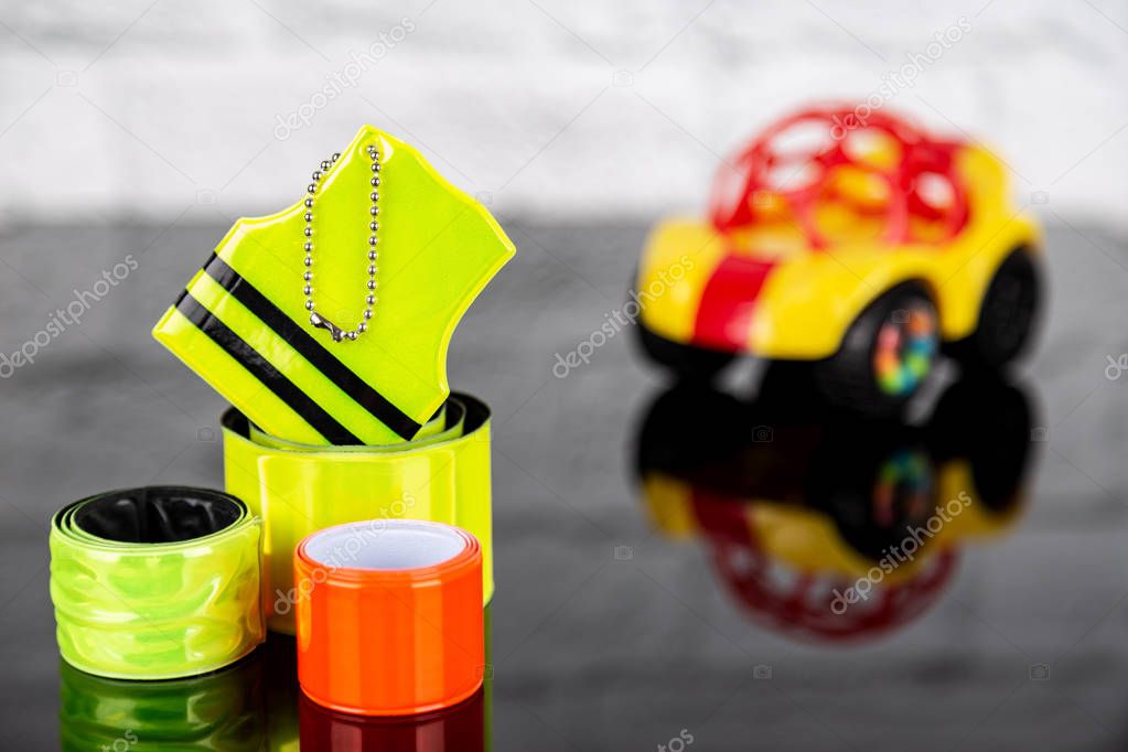 Pedestrain and children safety concept. Set of reflectors and blurred toy car on the background